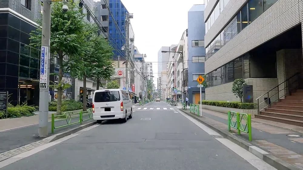 片側一車線の市街地で、左端の路側帯に白いワンボックス車が停車している車載カメラからの写真